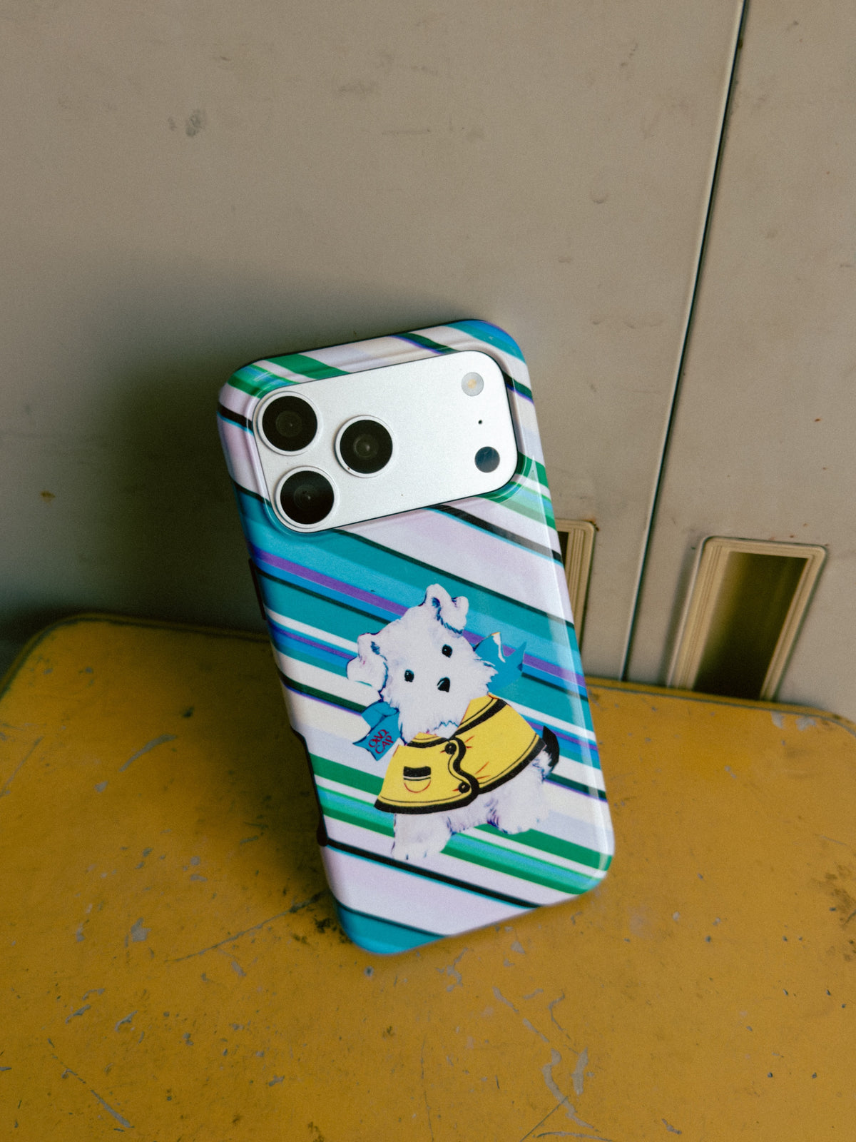 Dog on an Errand striped dog MagSafe phone case on a worn yellow surface