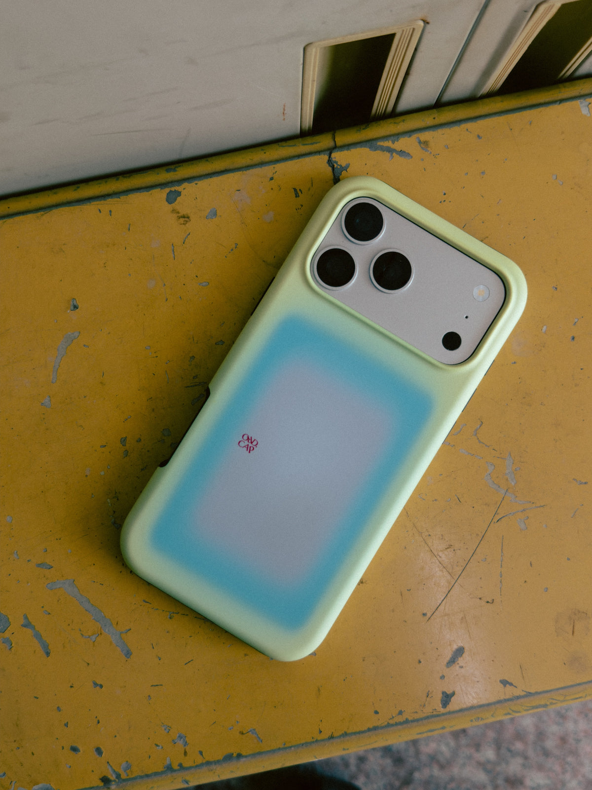 Lemon Window pale yellow gradient MagSafe phone case on a worn yellow surface