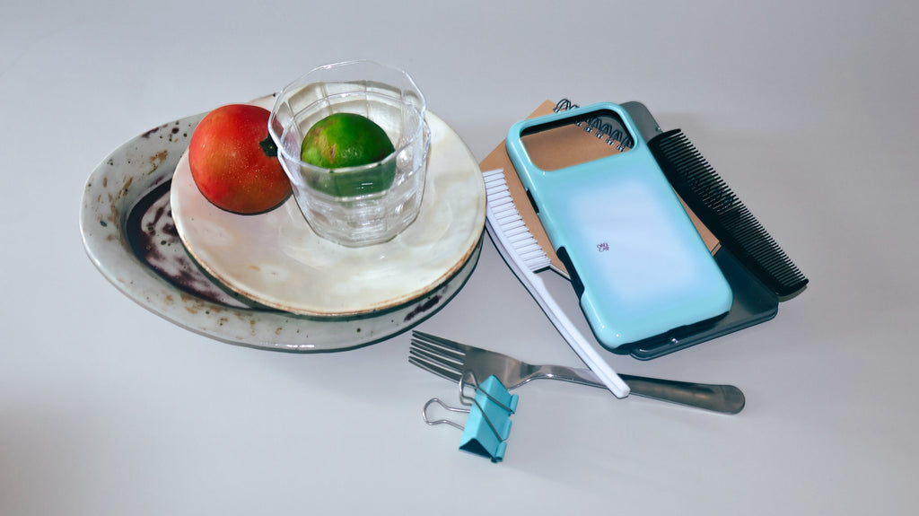 Mint Window aqua gradient MagSafe phone case beside fruit, glassware and tableware