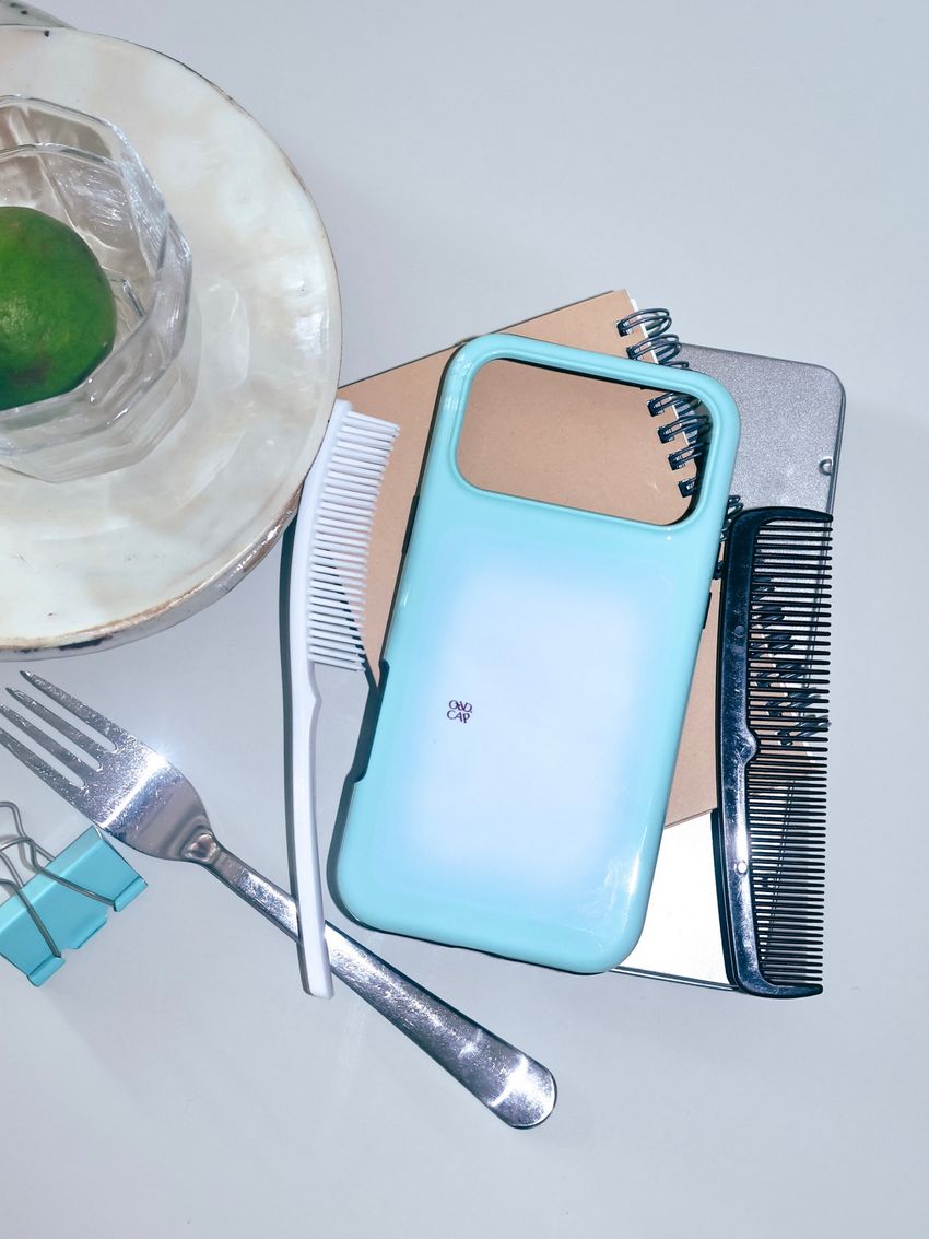 An ORD.CAP phone case beside late lunch tableware.