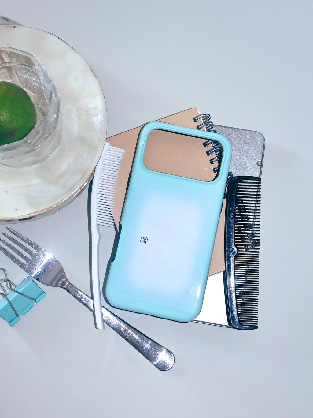 Mint Window phone case arranged with tableware and a green lime